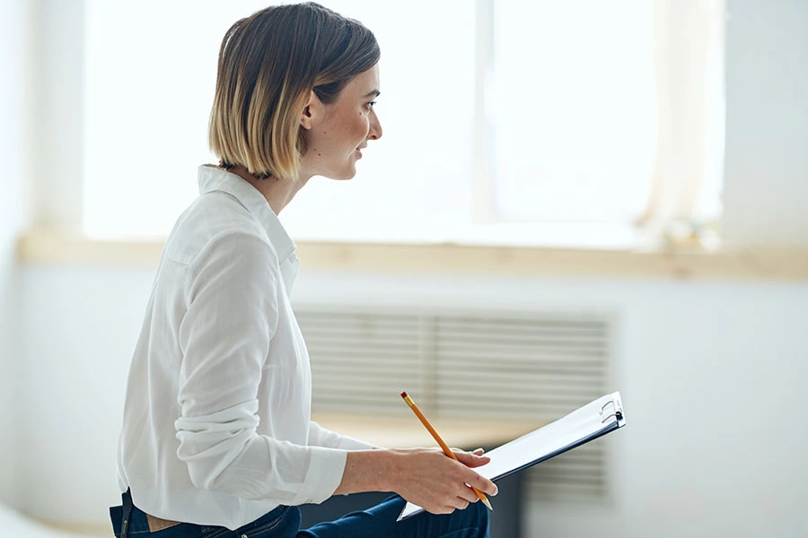 Formadora con libreta delante de ventana